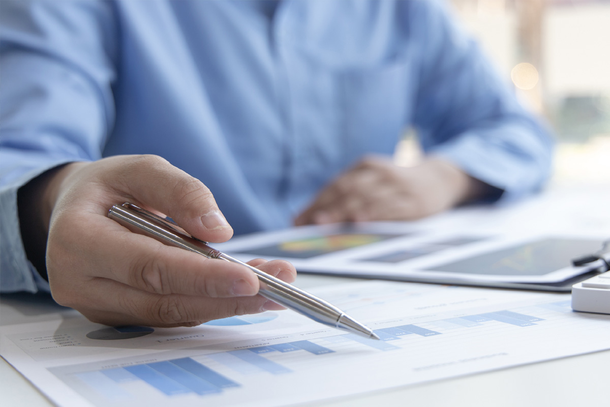 Mandanten Hand mit Stift über einem Vertrag